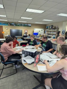 six people around a table playing a TTRPG